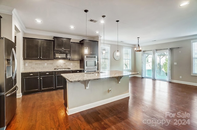 kitchen featuring stainless steel appliances, dark wood-type flooring, a kitchen island with sink, a breakfast bar, and pendant lighting