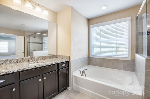 bathroom featuring tile patterned flooring, a wealth of natural light, vanity, and independent shower and bath