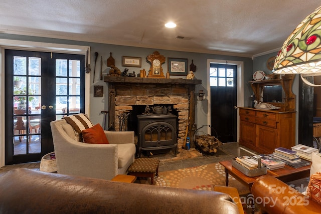 living room with french doors, crown molding, a wood stove, and a textured ceiling