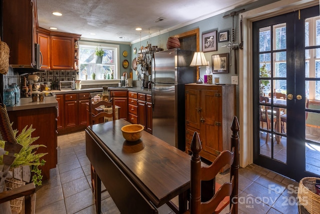 kitchen featuring a wealth of natural light, stainless steel appliances, crown molding, and french doors