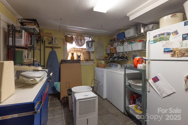 laundry room featuring a textured ceiling and washing machine and dryer