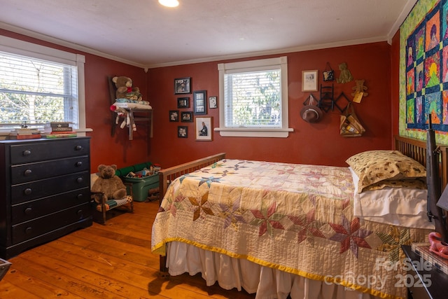 bedroom featuring wood-type flooring and crown molding