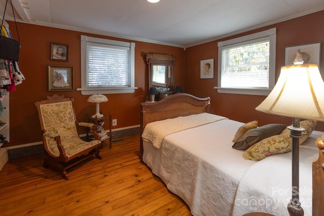 bedroom with wood-type flooring and ornamental molding