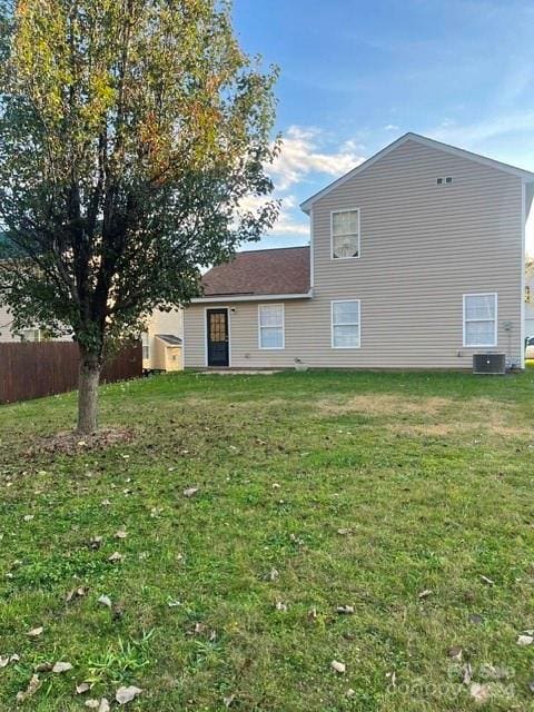 back of house with central AC and a yard