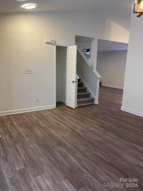 interior space featuring dark wood-type flooring and lofted ceiling