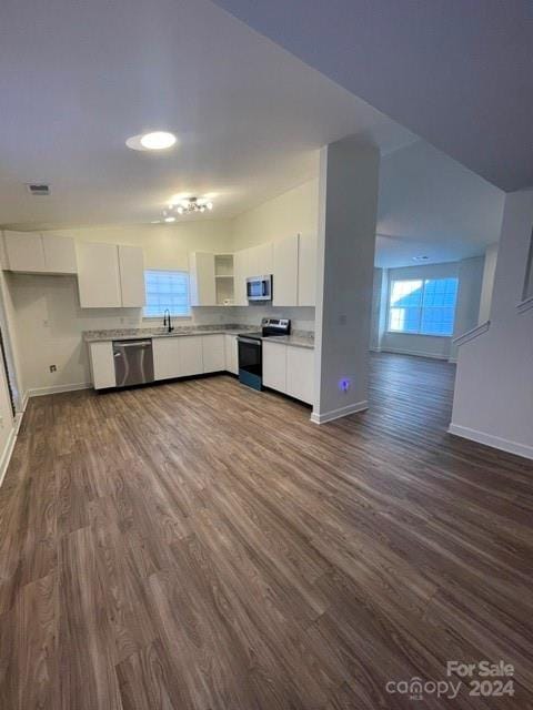 kitchen featuring white cabinets, appliances with stainless steel finishes, dark wood-type flooring, and sink