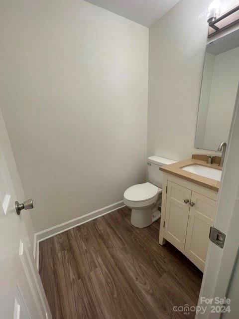 bathroom featuring vanity, hardwood / wood-style flooring, and toilet