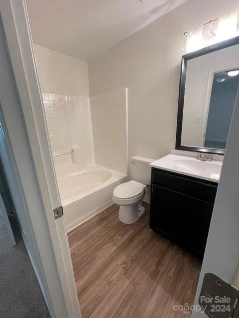 full bathroom with hardwood / wood-style flooring, vanity, toilet, and tub / shower combination