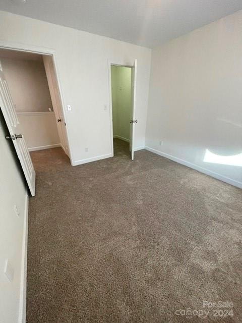 unfurnished bedroom with dark colored carpet