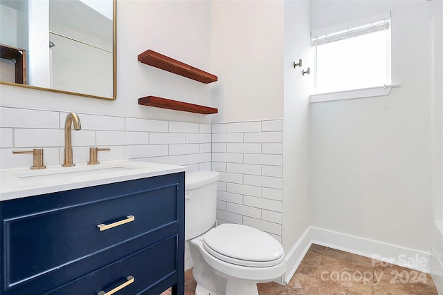 bathroom with tile patterned floors, vanity, toilet, and tile walls