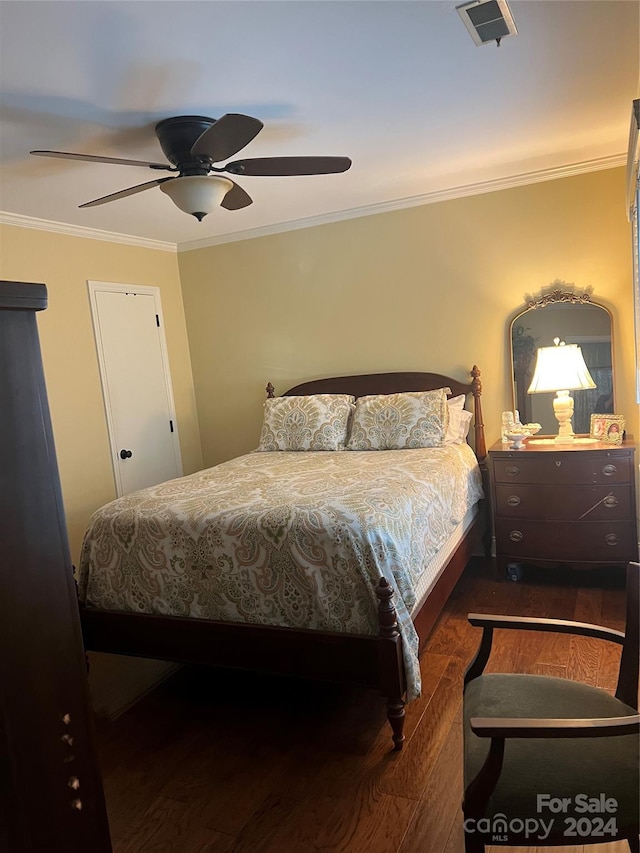 bedroom with dark hardwood / wood-style flooring, ceiling fan, and crown molding