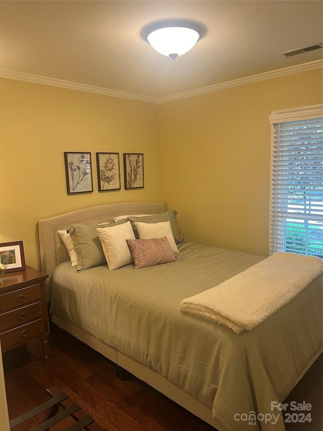 bedroom with dark hardwood / wood-style floors and crown molding