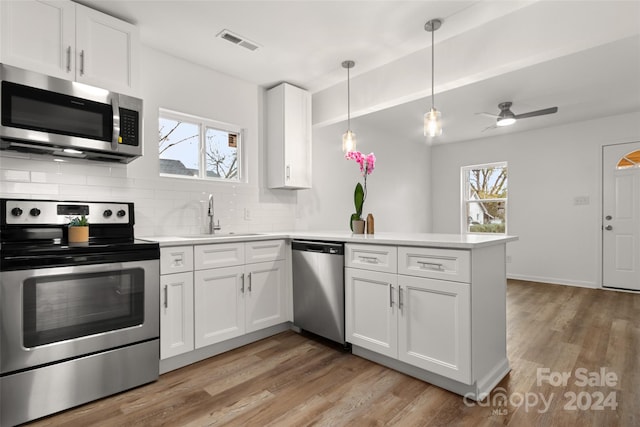 kitchen with stainless steel appliances, white cabinets, and kitchen peninsula