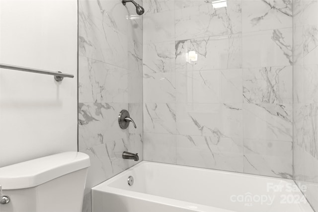 bathroom featuring tiled shower / bath and toilet