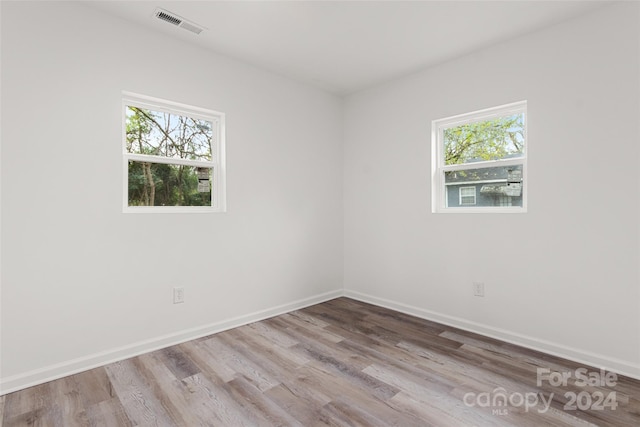 spare room featuring a healthy amount of sunlight and light wood-type flooring