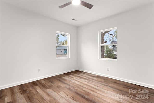 unfurnished room featuring hardwood / wood-style floors, ceiling fan, and plenty of natural light