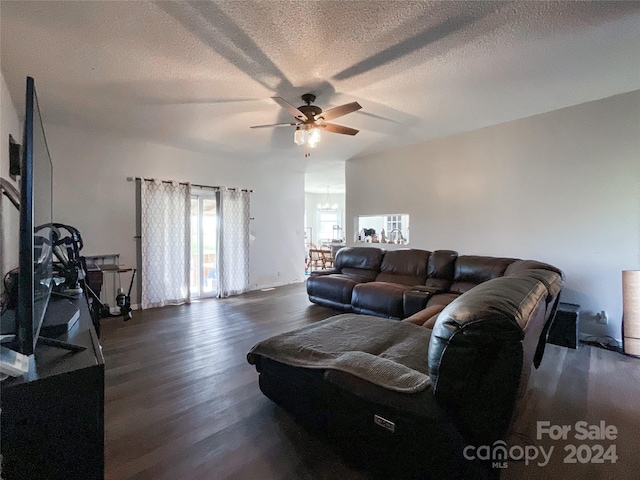 living room featuring ceiling fan, dark hardwood / wood-style flooring, and a textured ceiling