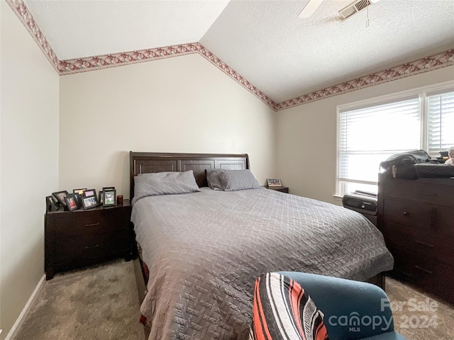 bedroom featuring carpet, a textured ceiling, ceiling fan, and lofted ceiling