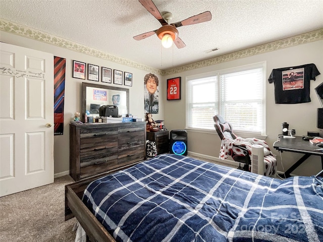 carpeted bedroom featuring ceiling fan and a textured ceiling