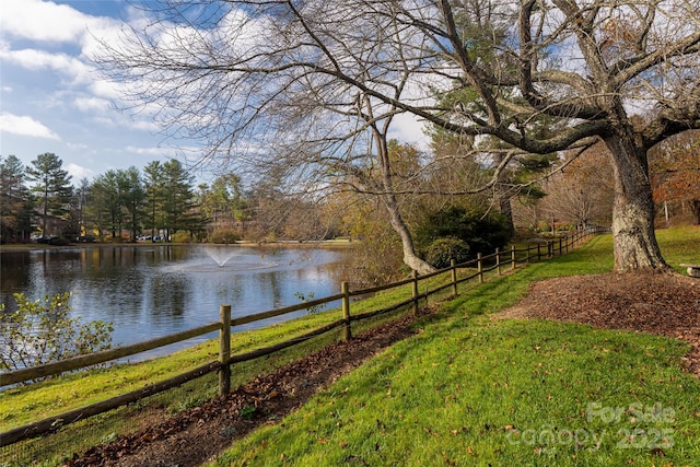 view of yard featuring a water view and fence