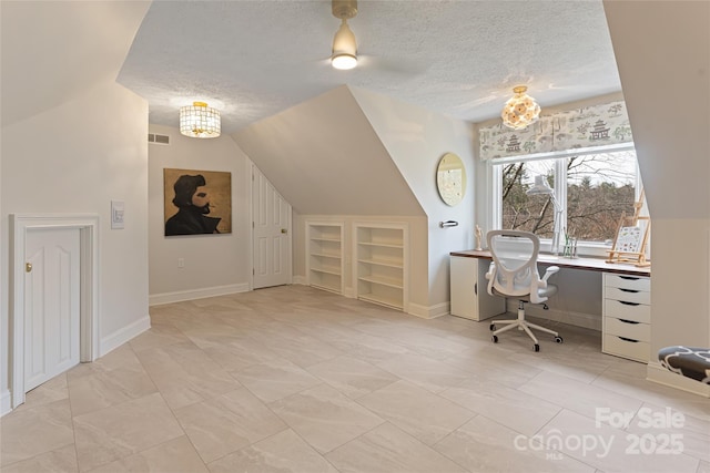 office area featuring built in shelves, visible vents, vaulted ceiling, and a textured ceiling