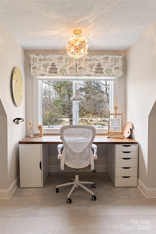 office space with a textured ceiling, baseboards, and a wealth of natural light