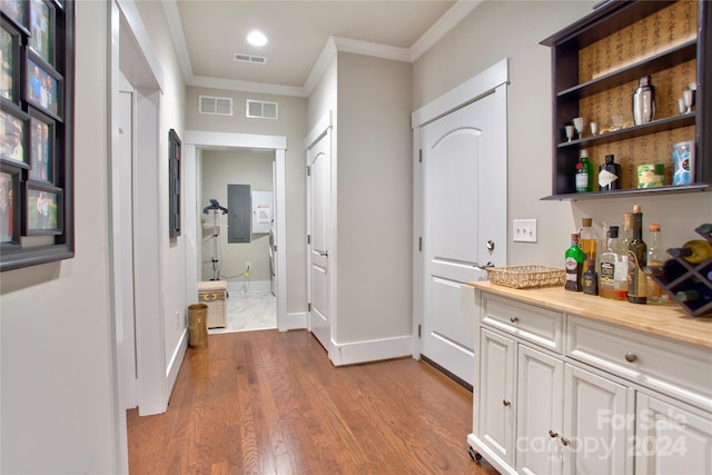 bar with white cabinetry, wood-type flooring, wood counters, and crown molding