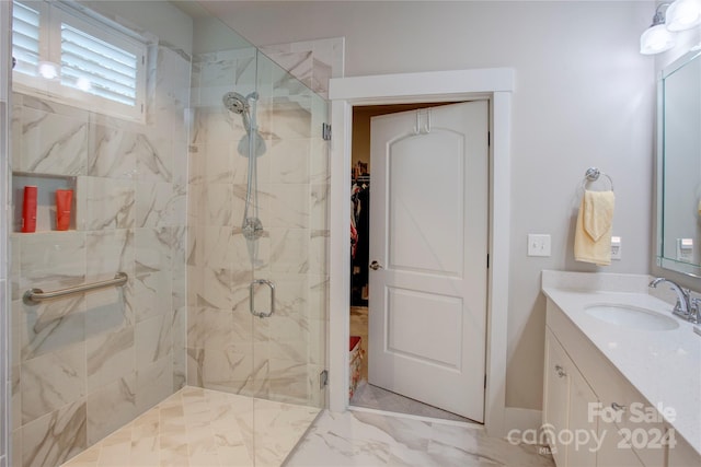 bathroom with vanity and a shower with door