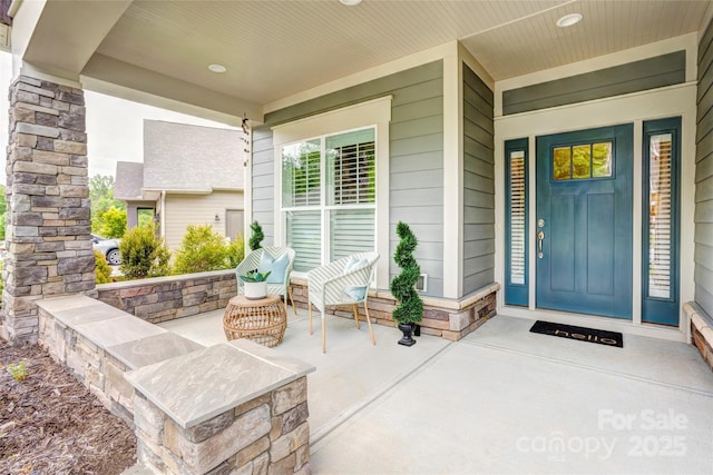property entrance with stone siding and covered porch