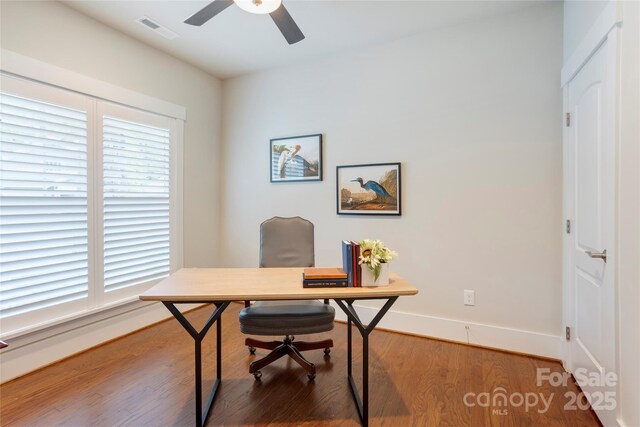 office area with baseboards, visible vents, wood finished floors, and a ceiling fan