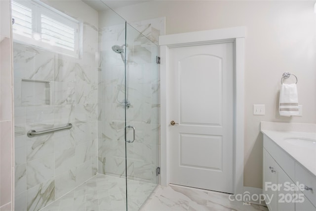 full bath with vanity, a marble finish shower, and marble finish floor