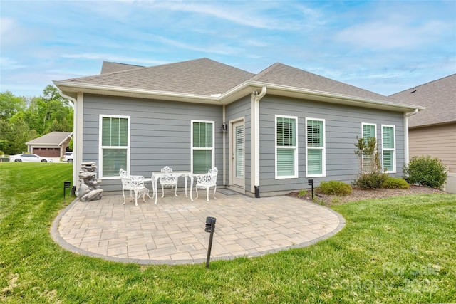 rear view of property with a yard, a patio, and a shingled roof