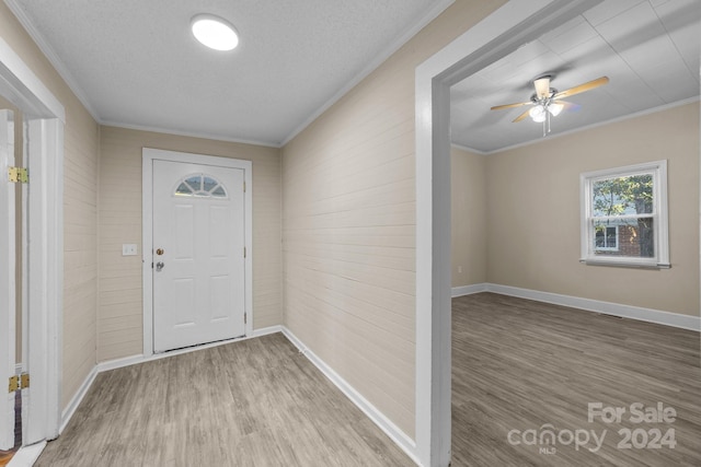 foyer featuring hardwood / wood-style floors, a textured ceiling, ceiling fan, and ornamental molding