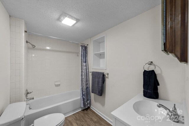 bathroom with hardwood / wood-style floors, shower / bathtub combination with curtain, a textured ceiling, and toilet