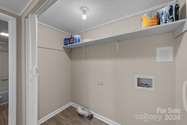 washroom featuring wood-type flooring, a textured ceiling, and washer hookup