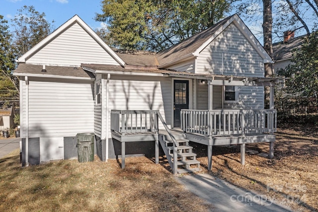 rear view of house featuring a wooden deck