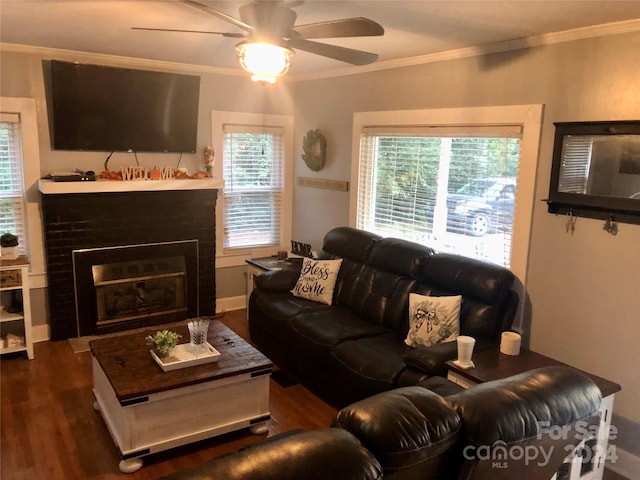 living room with ornamental molding, a brick fireplace, and dark wood-type flooring