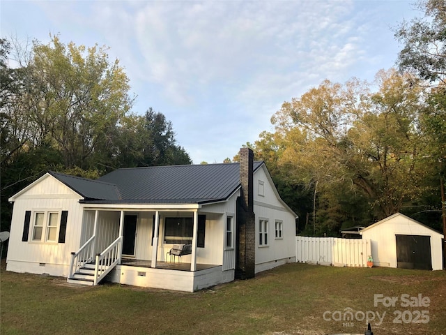 view of front of house with fence, crawl space, a front lawn, board and batten siding, and covered porch