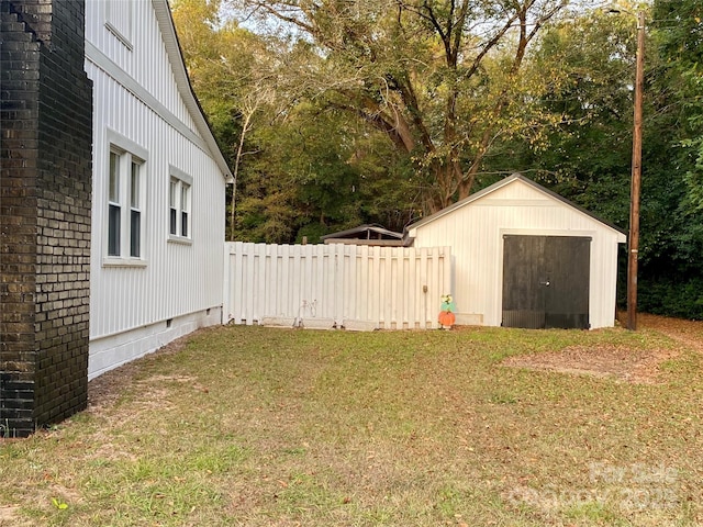 view of yard with an outbuilding, fence, and a storage shed