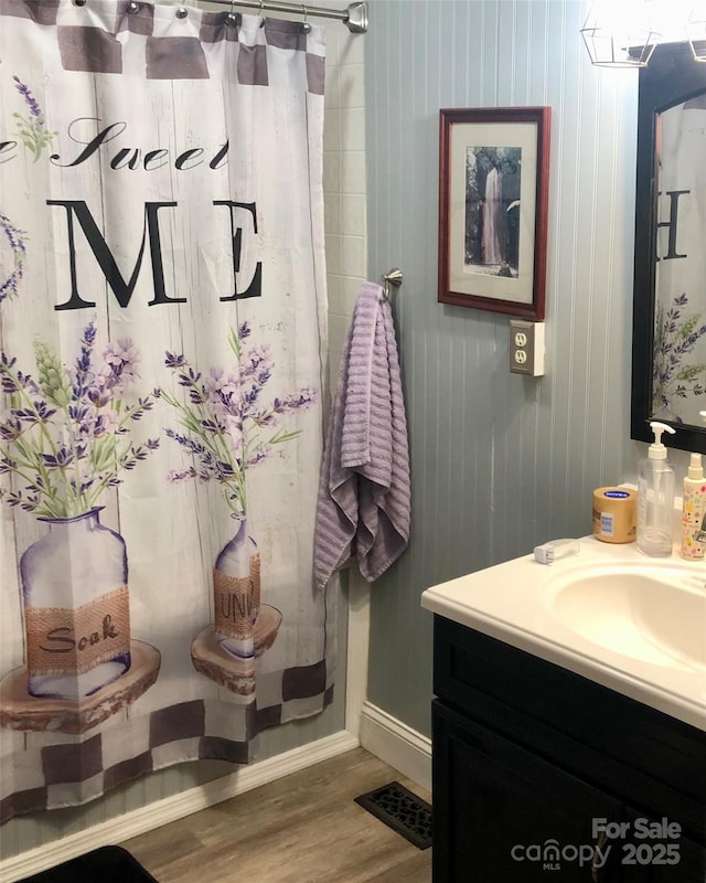 full bath with wood finished floors, vanity, a shower with shower curtain, and visible vents