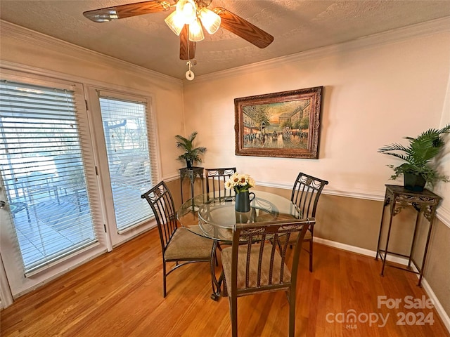 dining room featuring ornamental molding, a textured ceiling, and hardwood / wood-style flooring