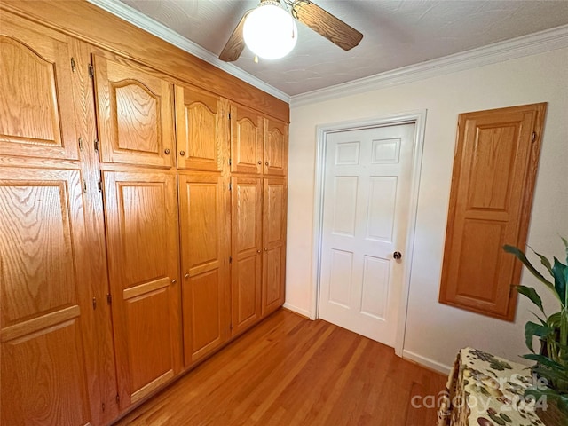 corridor with light wood-type flooring and ornamental molding