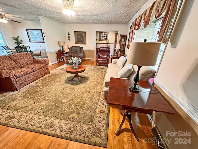 living room featuring a textured ceiling, hardwood / wood-style flooring, ceiling fan, and crown molding