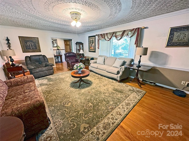 living room with hardwood / wood-style floors, a textured ceiling, and ornamental molding