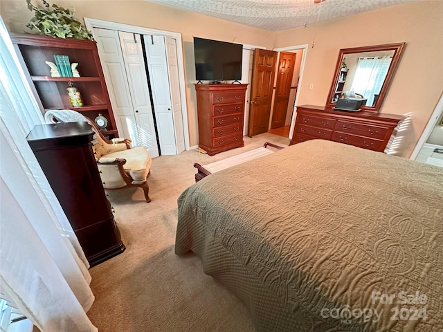 carpeted bedroom featuring a closet and a textured ceiling