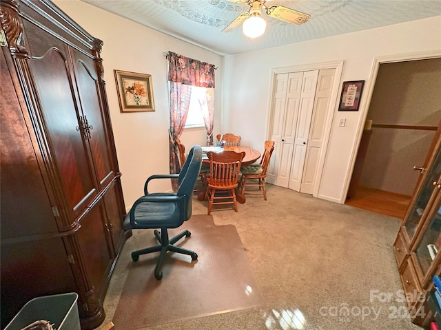 carpeted office featuring a textured ceiling and ceiling fan