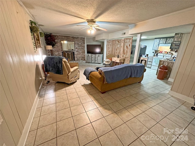 tiled living room featuring ceiling fan, a textured ceiling, and wooden walls