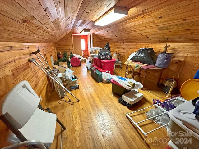 bonus room featuring wood-type flooring, wooden walls, wooden ceiling, and lofted ceiling