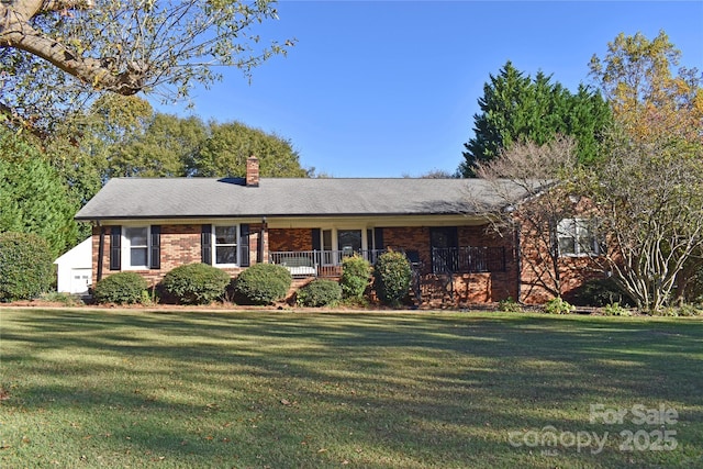 ranch-style home with brick siding, a chimney, and a front yard