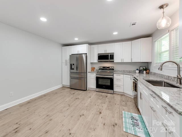 kitchen featuring white cabinets, light wood-type flooring, appliances with stainless steel finishes, and sink